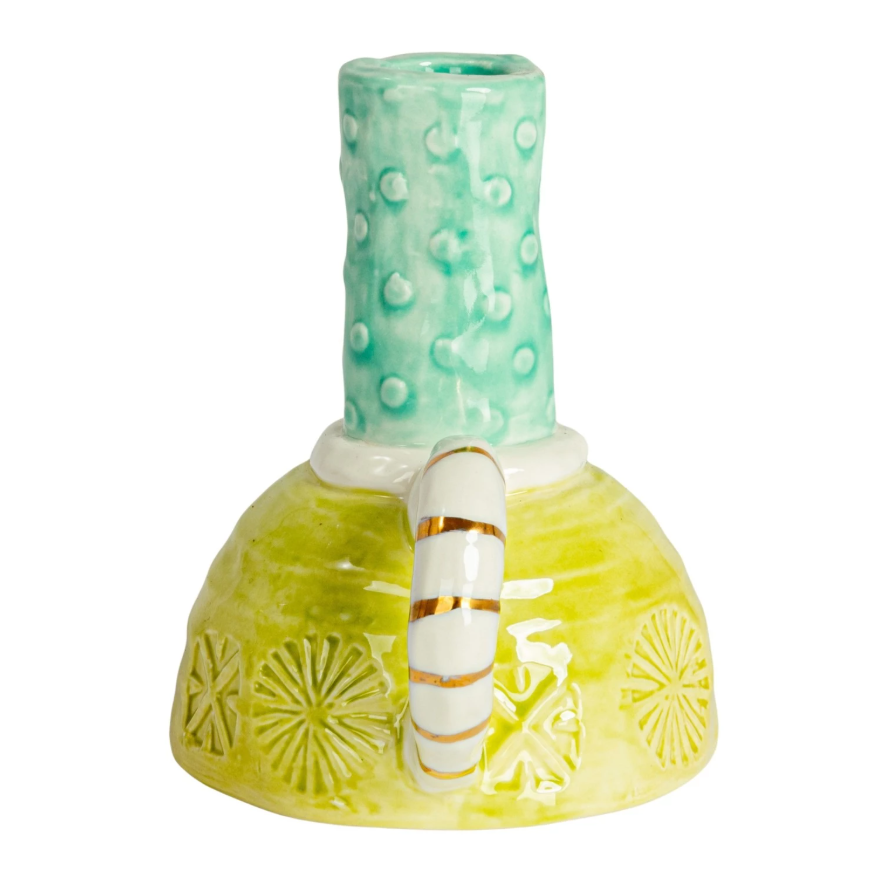 Hand-painted stoneware taper candle holder with dual handles and a multicolored rustic finish, from the side.