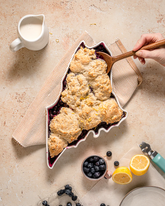 Maine state-shaped bakeware filled with fresh blueberry pie