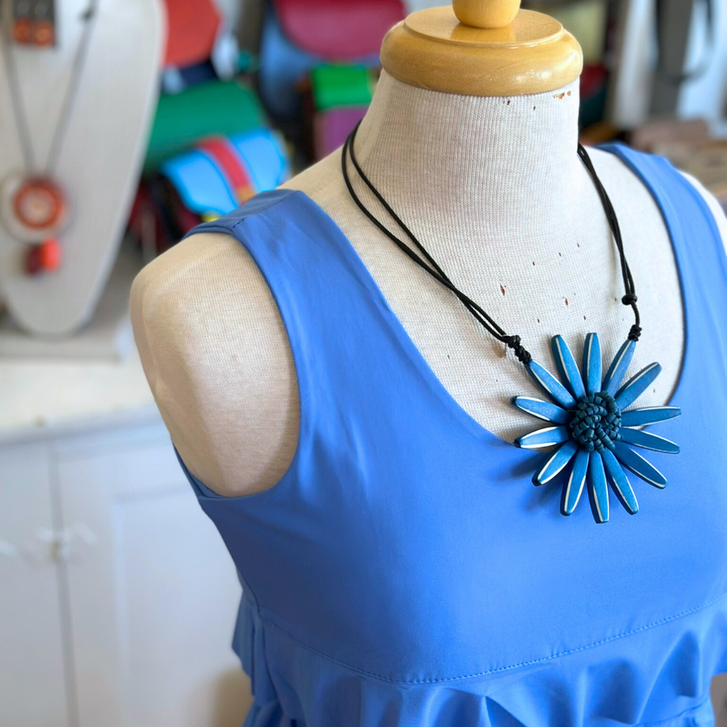 Woman wearing Lulu-B Sleeveless Cha Cha Dress featuring bold patterns, layered Cha Cha design, and UPF 50+ sun protection, perfect for spring and summer outings.​
