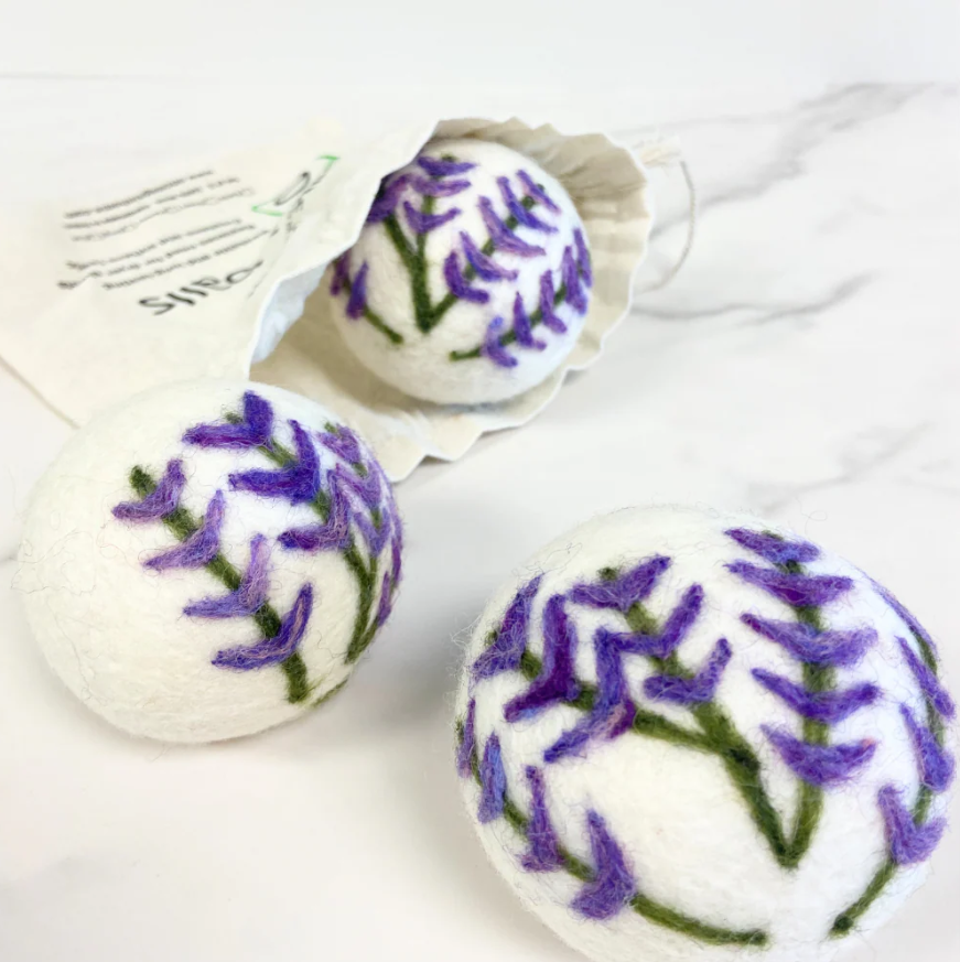 Lavender print wool dryer balls displayed in reusable storage pouch